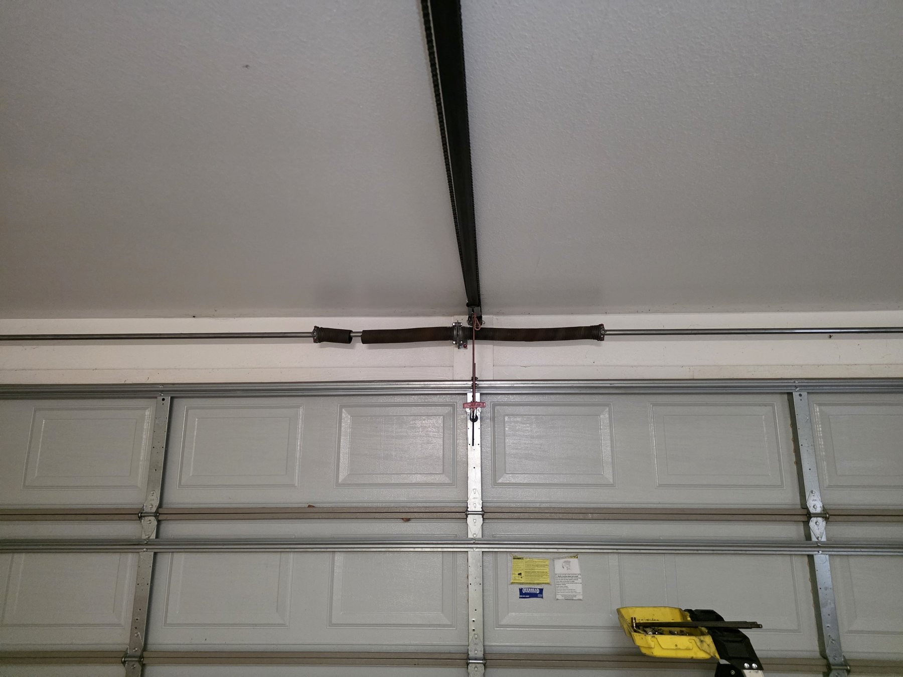 A new torsion spring installed above a garage door
